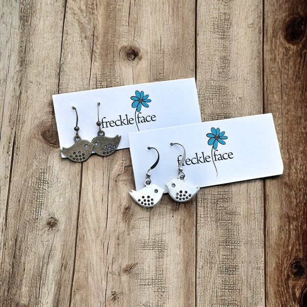 Antique brass and silver bird outline earrings with delicate cutout design