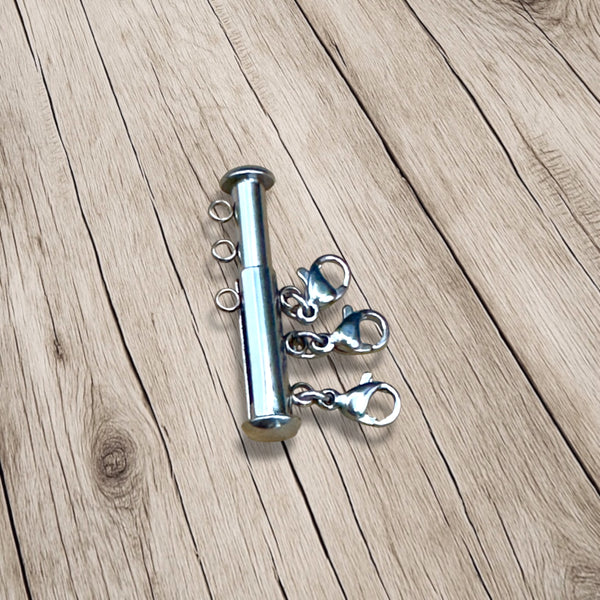 Silver-tone necklace layering connector with multiple clasps shown from side angle