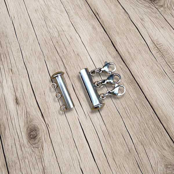 Open magnetic layering clasp showing both sides on rustic wood surface