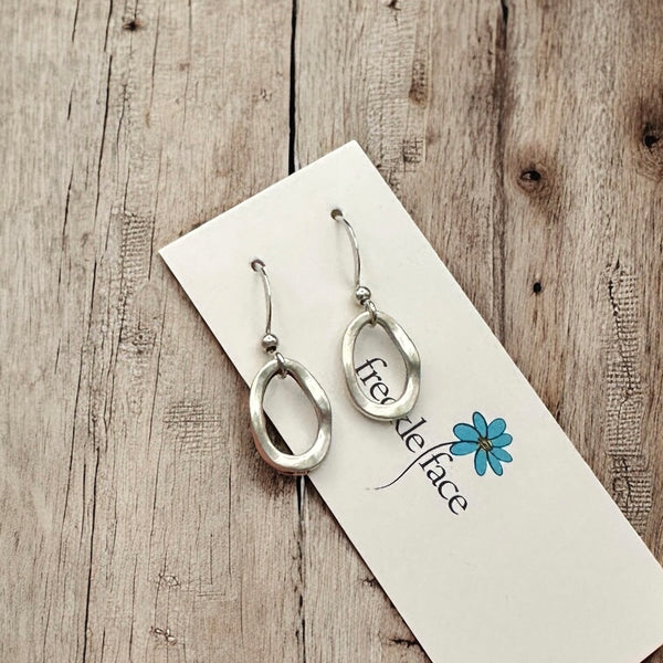 Single hoop matte drop earrings with a wood background