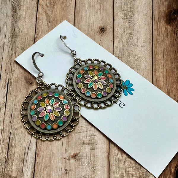 Enamel flower earrings in antique bronze with crystal center on jewelry card