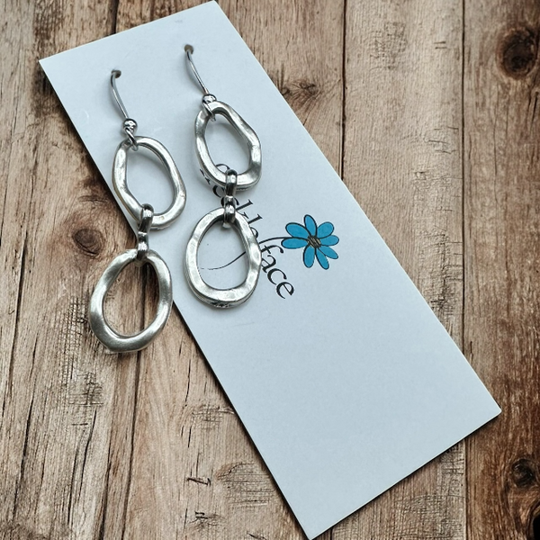 Matte silver double dangle circle earrings with rustic wood background