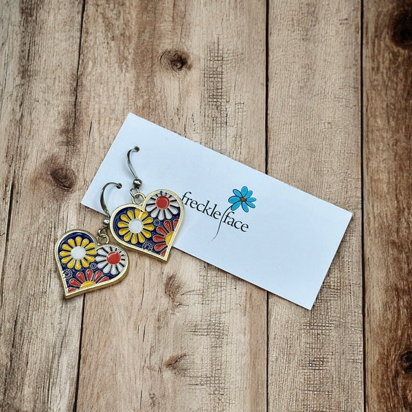 Colorful ’70s-style flower dangle earrings on rustic wood background