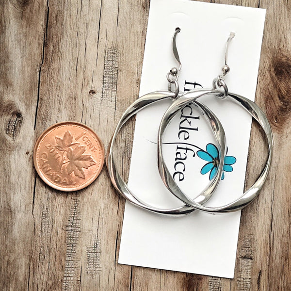 Elegant twisted hoop earrings on jewelry display card