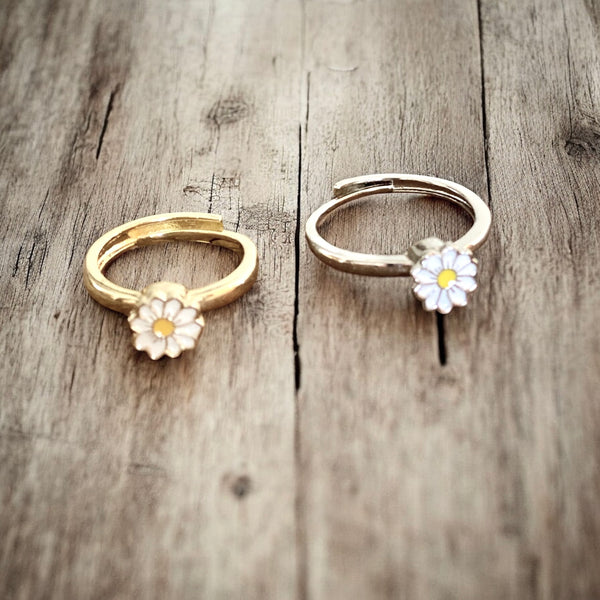 Adjustable daisy fidget ring with spinning charm on neutral background