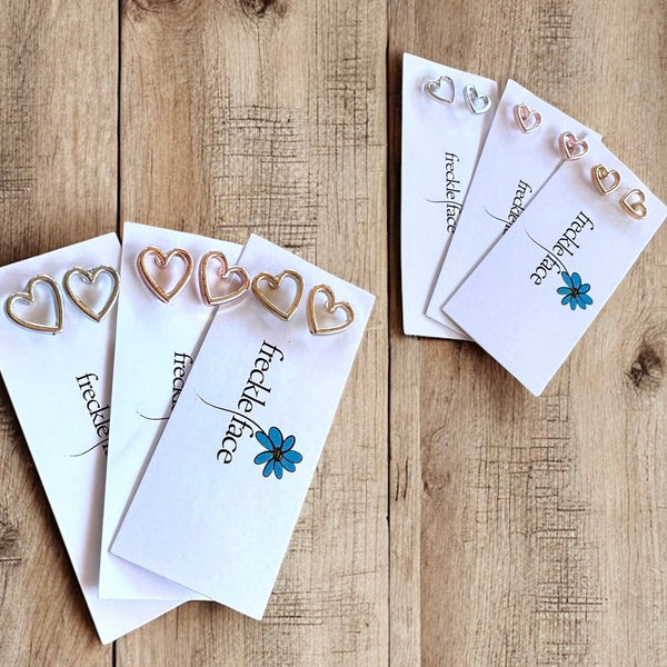 Open heart stud earring in two sizes and 3 colors displayed on white cards