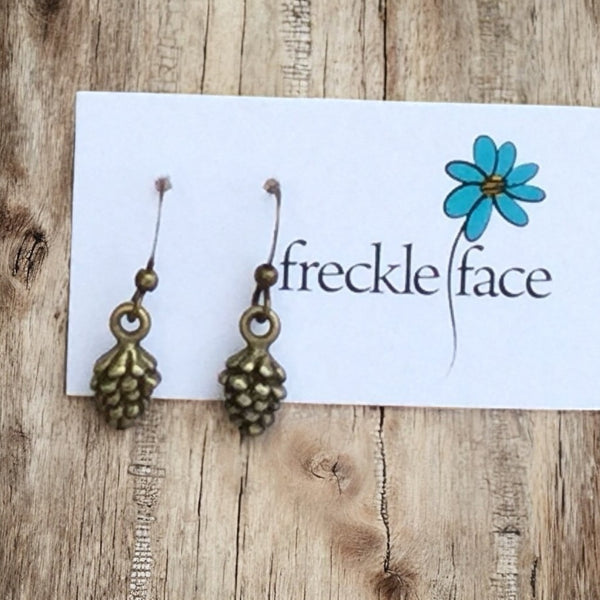 Close-up of antique brass pinecone earrings on earring card