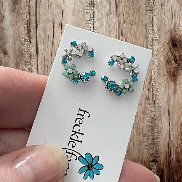 Crescent bloom stud earrings in rhodium plating with sparkly tiny glass stones in blue, white and green.