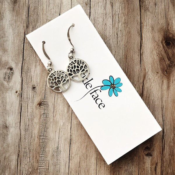 Tiny tree cutout dangle earrings in antique silver on jewelry card