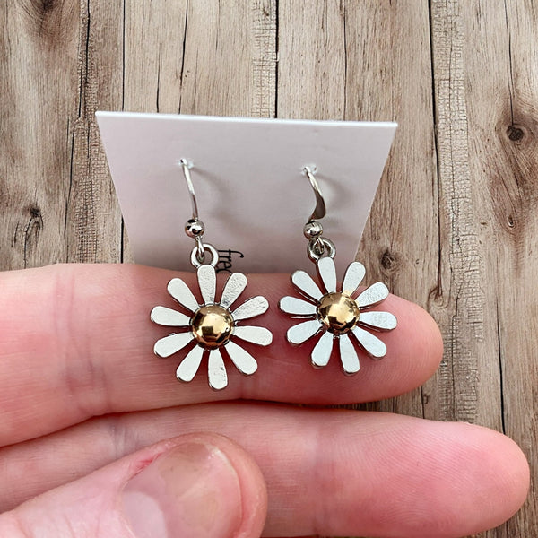 daisy earrings with silver petals and gold center on white card with wood background