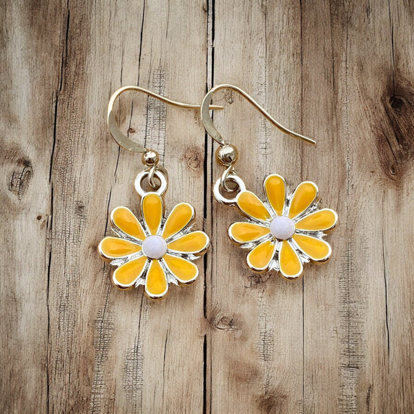 Yellow enamel flower dangle earrings with white center, close-up