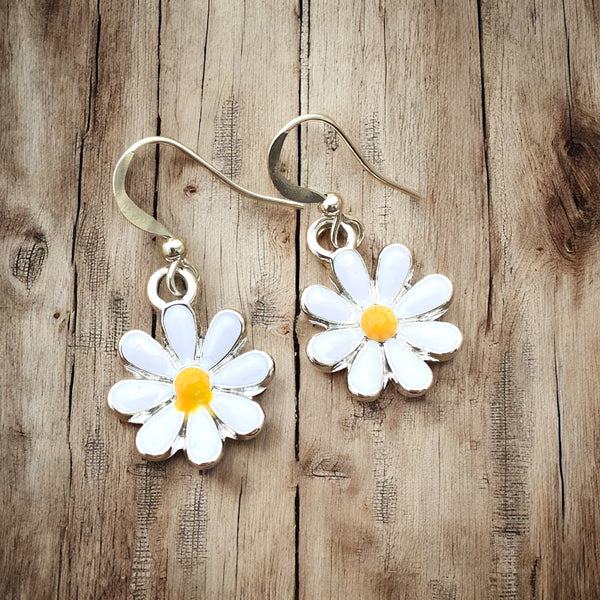 White petal flower hook earrings with yellow center on rustic boho wood background