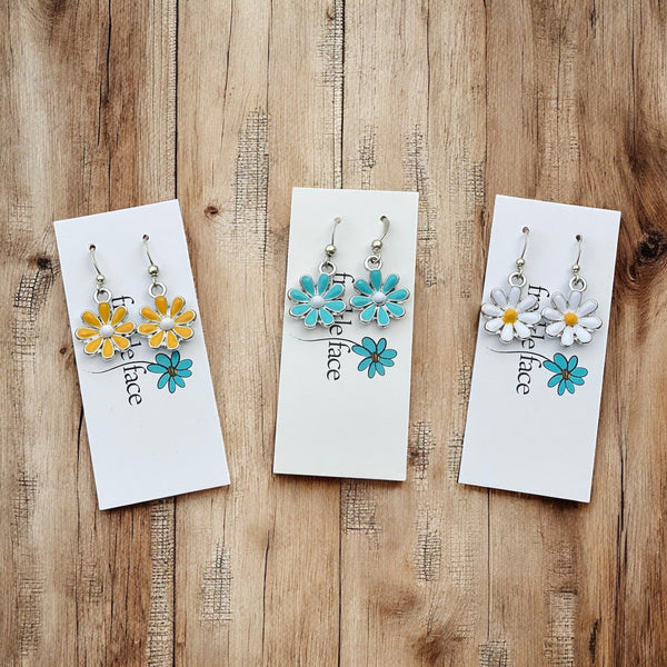 Blue yellow and white enamel daisy flower hook earrings on white jewelry card