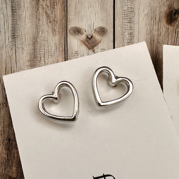 8mm non tarnishing rhodium silver simplistic heart stud earrings on neutral background
