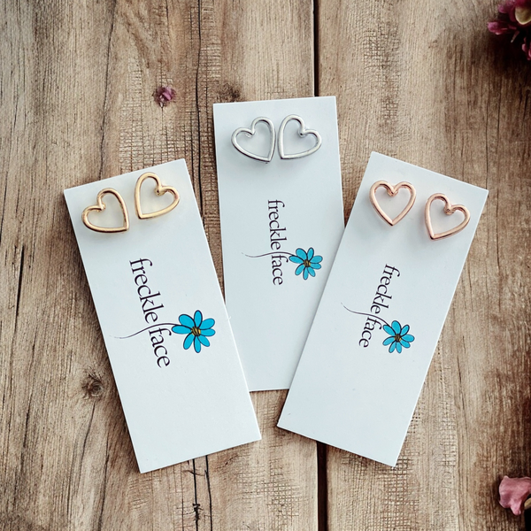 Set of open heart studs in silver, gold, and rose gold displayed together