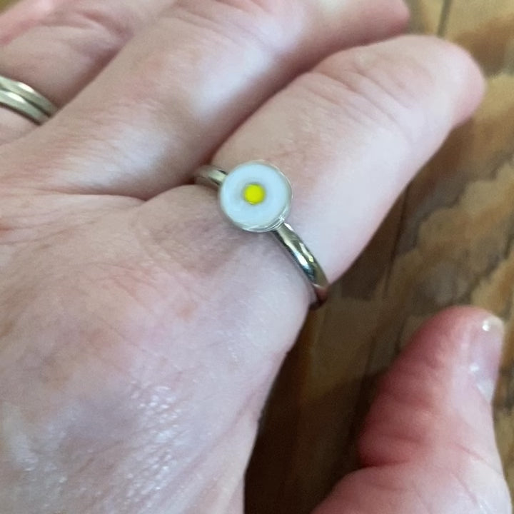 Close-up of daisy fidget ring in motion showing spinning action for anxiety relief