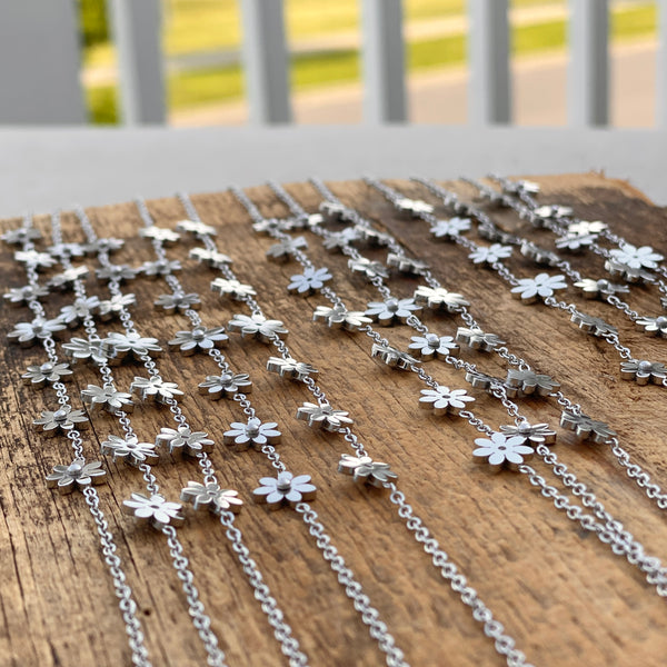 Boho flower stainless anklets laid out on wood