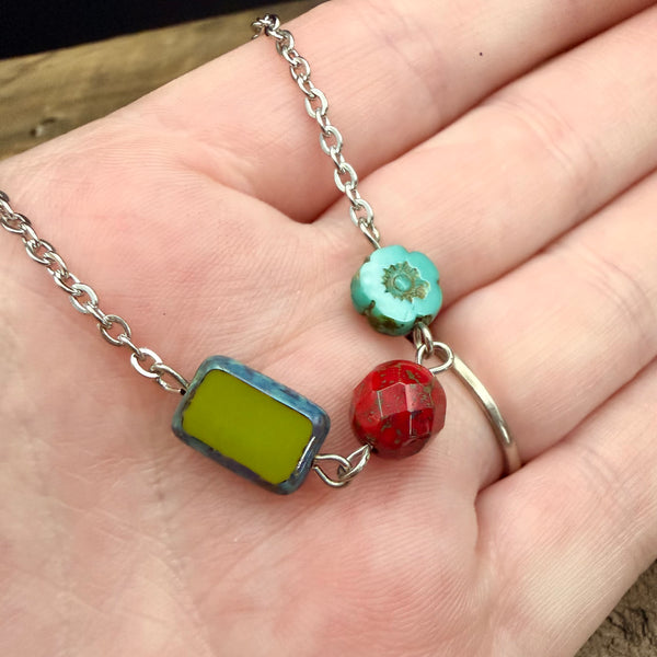 Close up of colorful Czech glass beads linked on stainless steel chain necklace