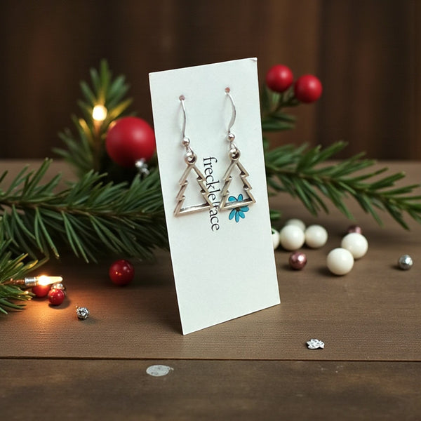 Matte rhodium Christmas tree earrings in cookie cutter style on Freckle Face card – minimalist holiday jewellery