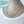 Mannequin wearing a layered necklace with a flower pendant on a light blue background
