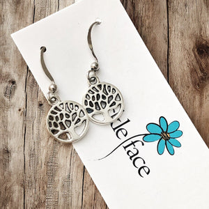 Close-up of round tree silhouette pendant earrings with rhodium hooks